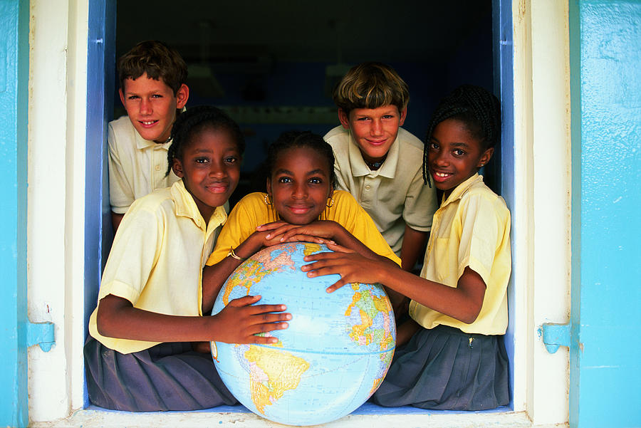 Teenage boys (12-14) posing around large globe Photograph by John P Kelly