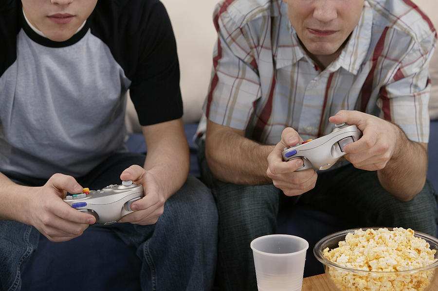 Teenage boys playing videogames Photograph by Comstock Images
