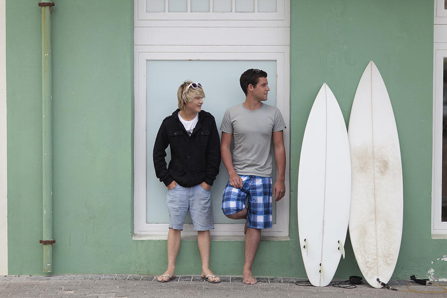 Teenage boys standing with surfboards Photograph by Hybrid Images