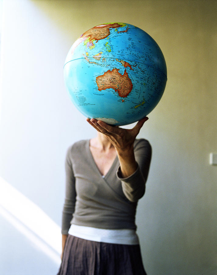 Teenage girl (15-17) holding globe (focus on Australia) Photograph by Blasius Erlinger