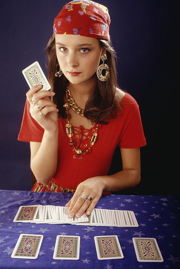 Teenage girl (16-17) using tarot cards, portrait Photograph by David De Lossy