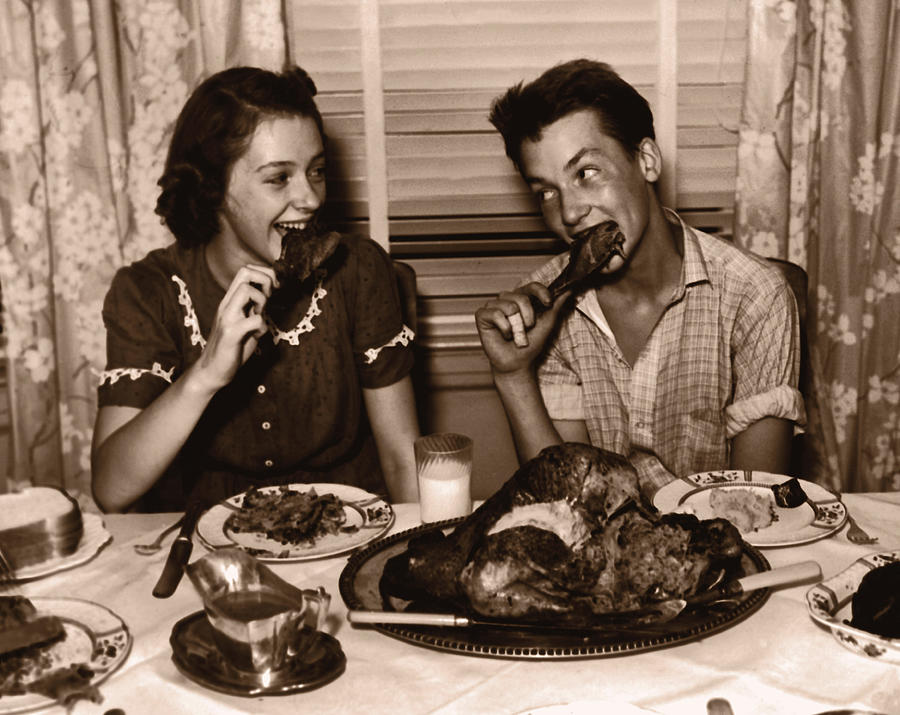 Teenage girl and boy (15-17) eating turkey dinner (B&W sepia tone) Photograph by Fpg