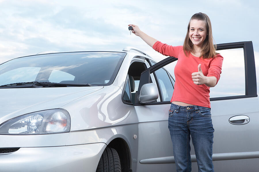 Teenage girl holding keys of new car Photograph by Gladiolus