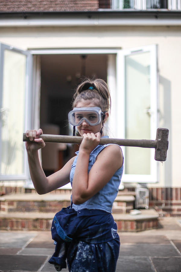 Teenage girl holding sledgehammer Photograph by Paul Mansfield Photography