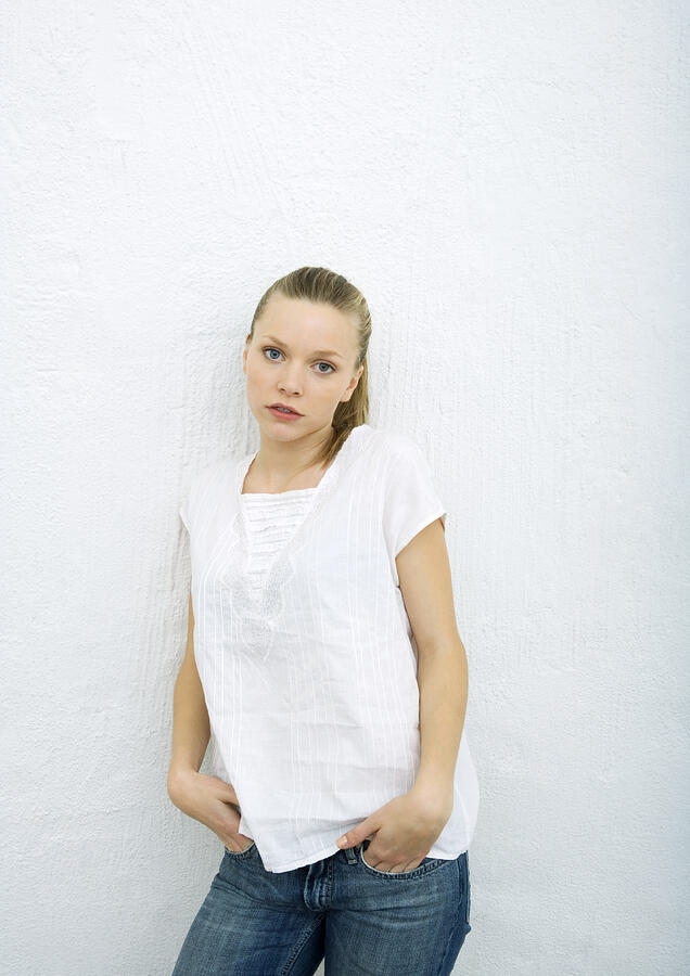 Teenage girl leaning against wall, looking at camera, portrait Photograph by PhotoAlto/Sigrid Olsson