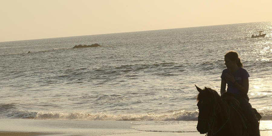 Teenage girl riding a horse on the beach Photograph by Fotosearch