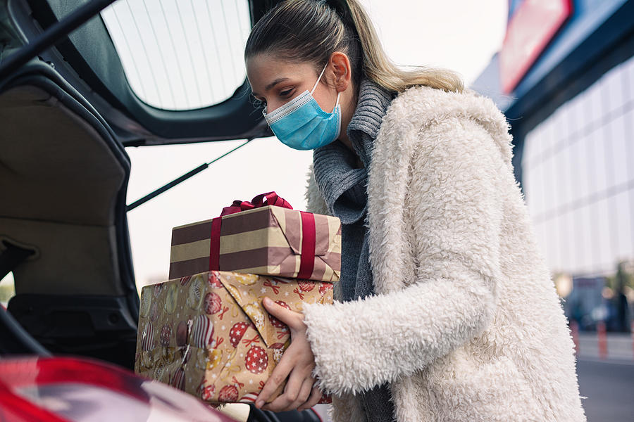 Teenage girl wears a protective mask while shopping for Christmas during COVID-19 pandemic Photograph by Kajakiki