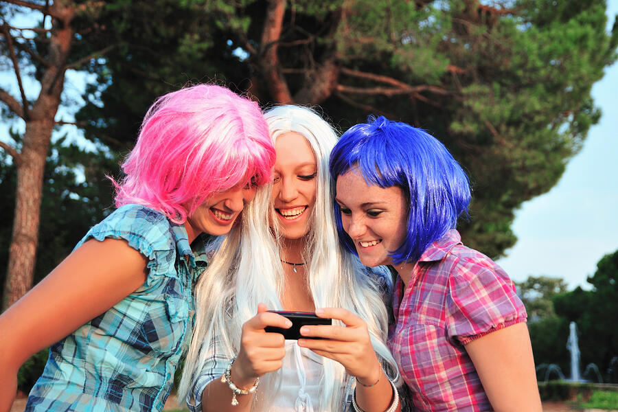 Teenage girls wearing colorful wigs Photograph by Daniela Buoncristiani