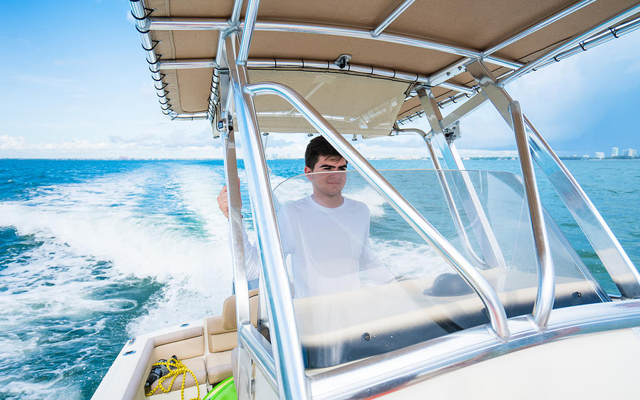 Teenager driving a boat Photograph by Thepalmer