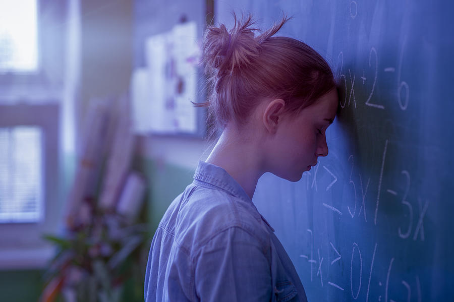 Teenager girl in math class overwhelmed by the math formula. Pressure, Education, Success concept. Photograph by AndreaObzerova