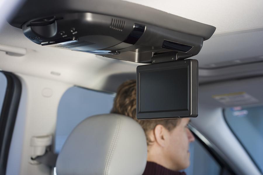 Television screen in car with man driving Photograph by Tetra Images
