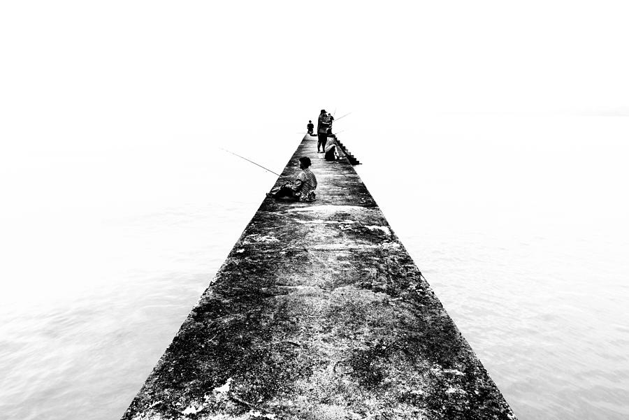 TELUK PELANDUK, MALAYSIA - 24TH DEC 2017; People cast the fishing rod to the sea. Black and white for classic view on old jetty. The old jetty still use for fisherman on fishing activities. Photograph by Shaifulzamri