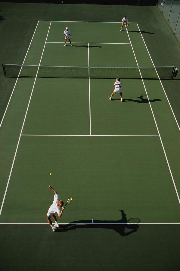 Tennis, men playing doubles on green court, elevated view Photograph by David Madison