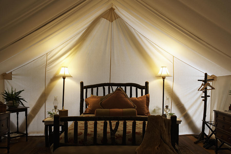 Tent interior with bed and lamps. Photograph by Ryan McVay