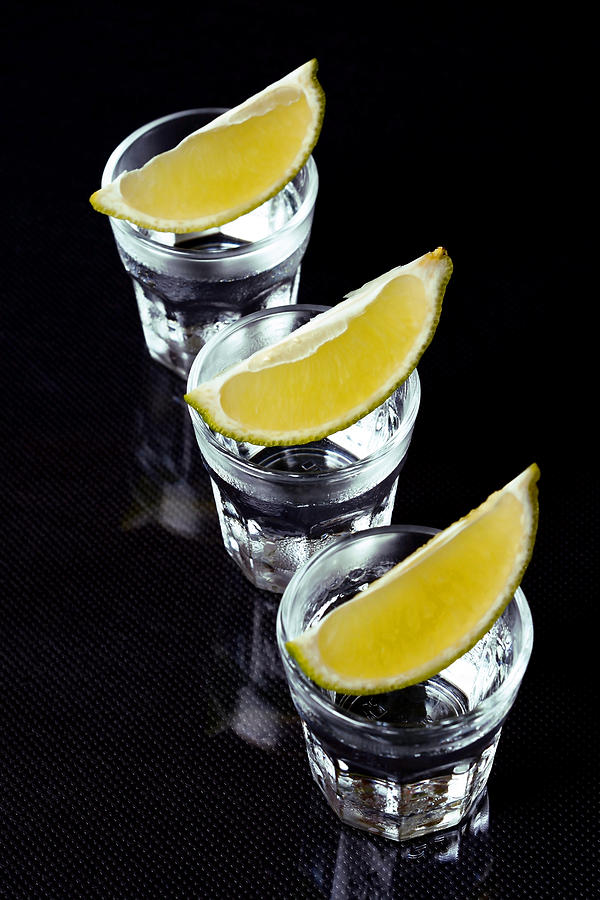 Tequila with lime on black background. Photograph by Madaland