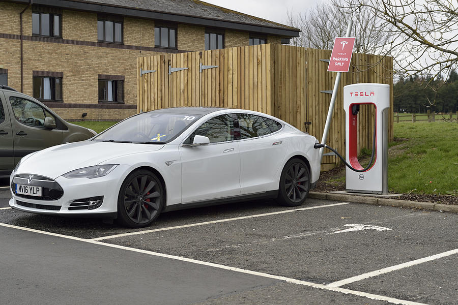 Tesla model S electric car parked at a charging station Photograph by JohnFScott