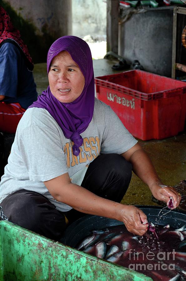 Thai Muslim woman in sweat pants and hijab headscarf guts and cleans fish Pattani Thailand Photograph by Imran Ahmed