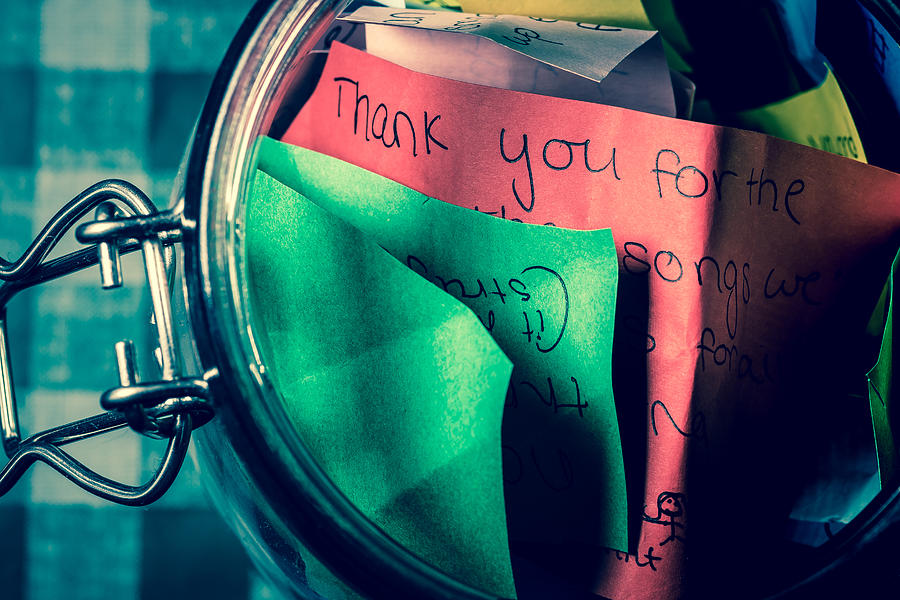 Thank you jar with messages written on coloured paper Photograph by Niall_Majury