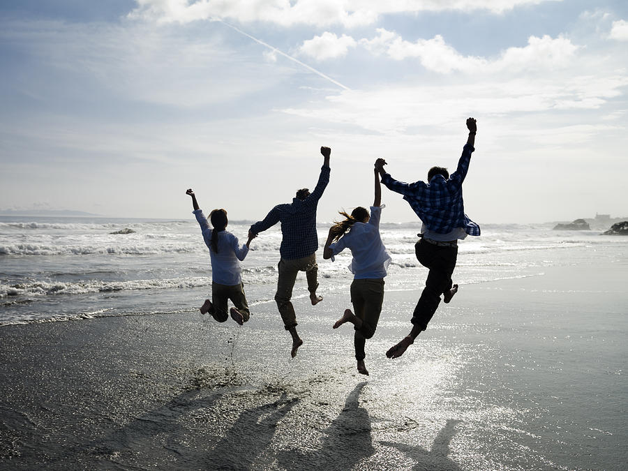 The couples who jump all at once in a beach Photograph by Michael H