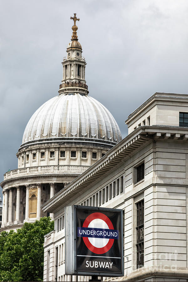The dome of St Pauls cathedral behind a London underground roundel sign. Focus on the iconic red, white and blue tube logo in foreground. Photograph by Jane Rix