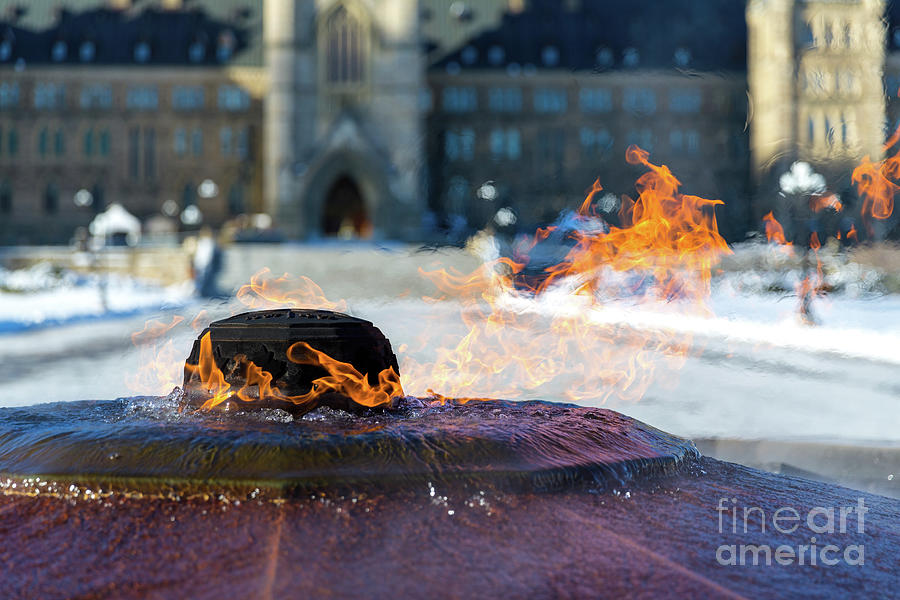 The eternal flame burns outside of a snow covered Canadian Parliament building in Ottawa, Ontario. It commemorates the 100th anniversary of the Confederation and the fountain never freezes Photograph by Jane Rix