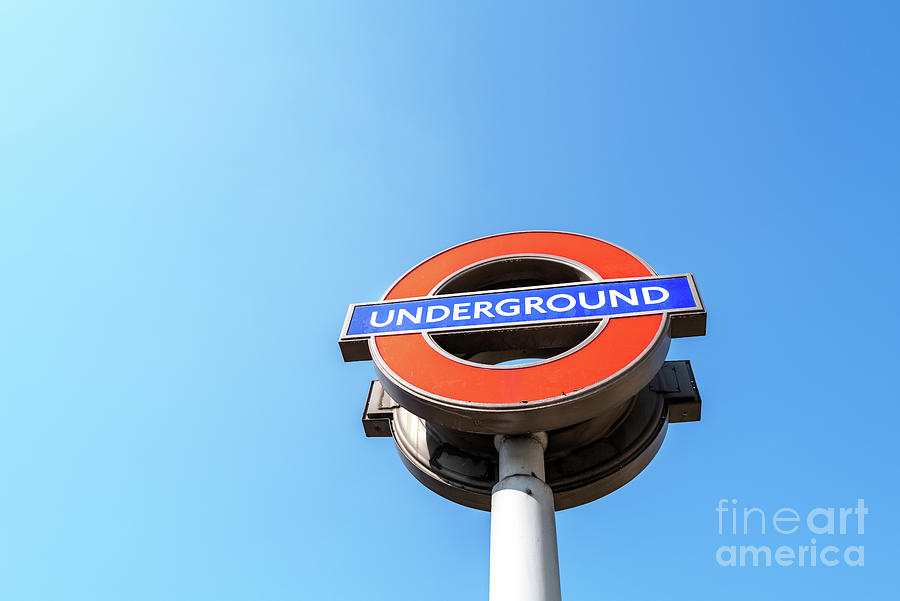The iconic London Underground roundal sign against a blue sky ba Photograph by Jane Rix
