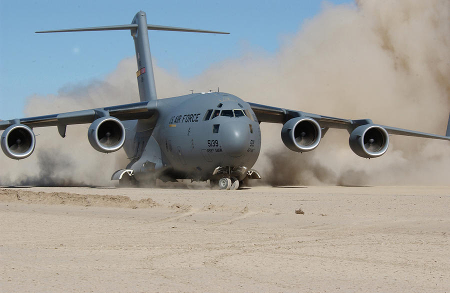 The jet engines of an Air Force C-17 Globemaster III kick up clouds of ...