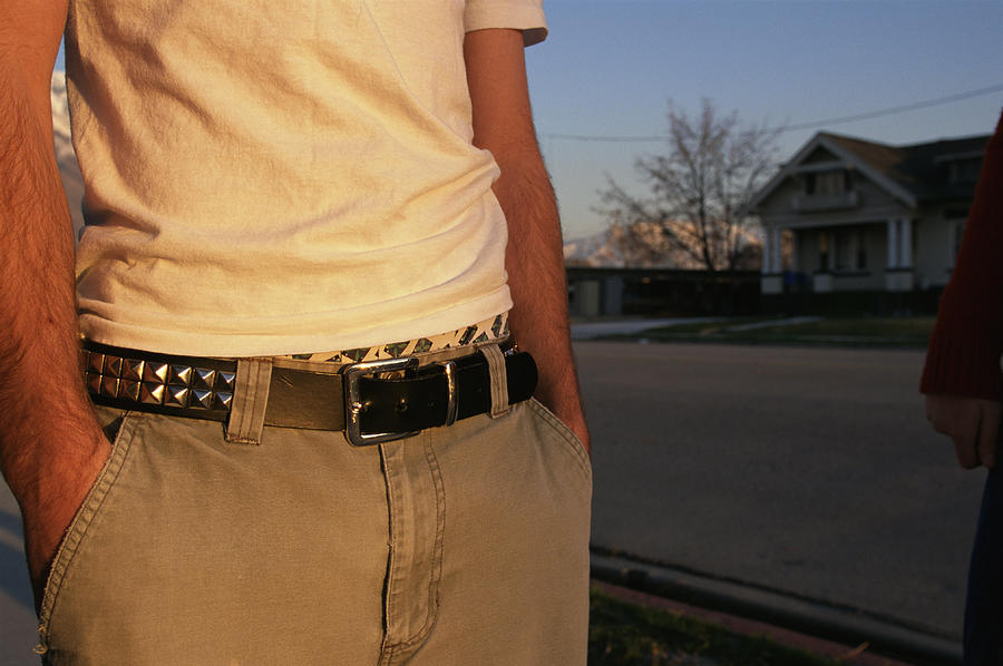The Mid-section Of A Teenage Boy In A Yellow Shirt And Tan Pants With His Hands In His Pockets Photograph by Photodisc
