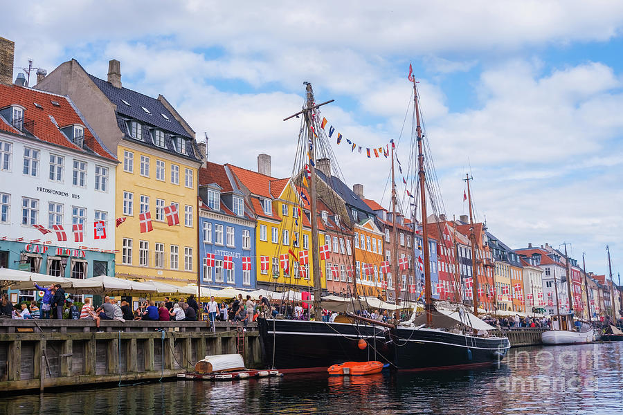  The most famous canal in Copenhagen with its quaint colorful houses overlooking the docked sailboat Photograph by Joaquin Corbalan