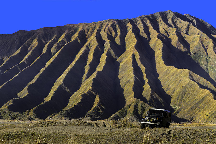 The mountain ridge line of Mt.Bromo volcano with a car in foreground, East Java, Indonesia. Photograph by Copyright by Siripong Kaewla-iad