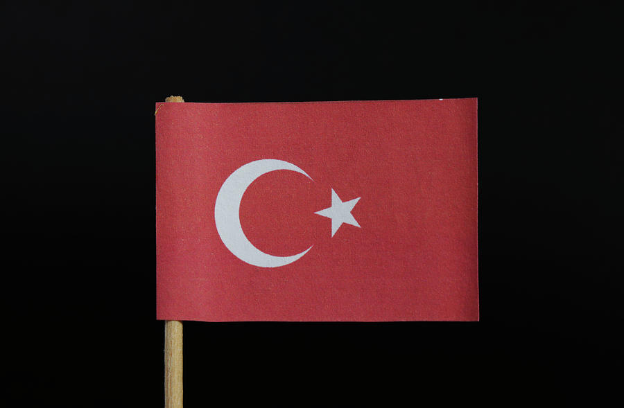 The national flag of the Republic of Turkey on toothpick on black background. A red field with a white star and crescent slightly left of center Photograph by Vaclav Sonnek