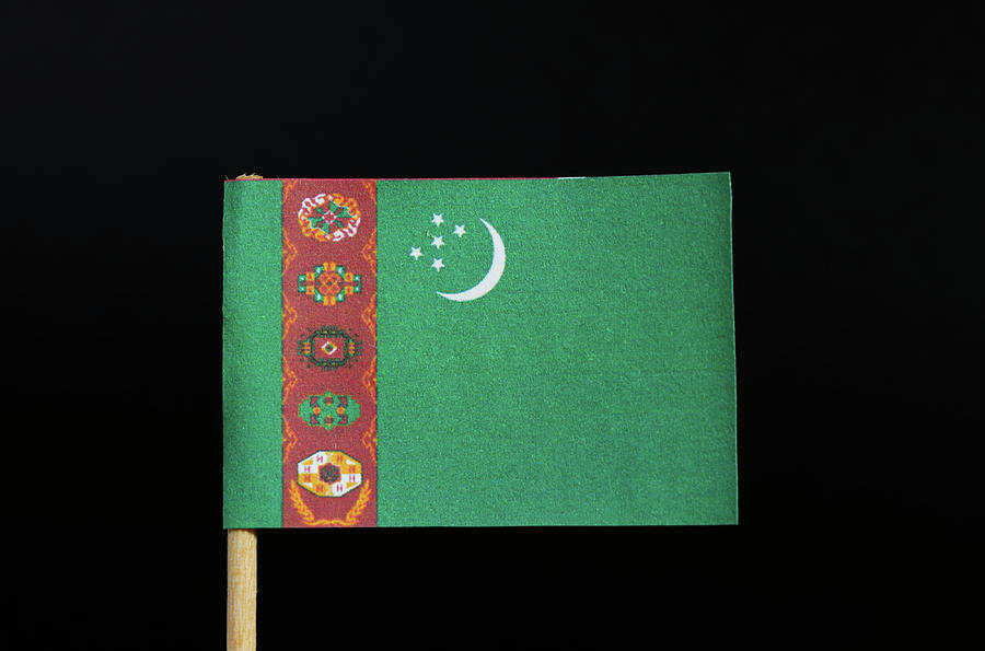 The national flag of Turkmenistan on toothpick on black background. A green field with a vertical red stripe near the hoist side Photograph by Vaclav Sonnek