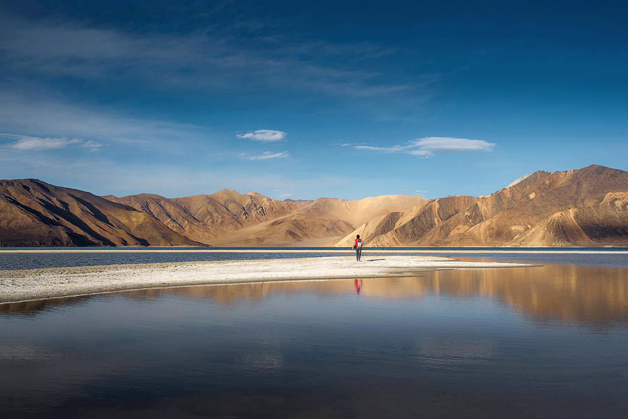 The person look at mountains in Pangong Lake and blue sky, Leh Ladakh. Photograph by Beerpixs