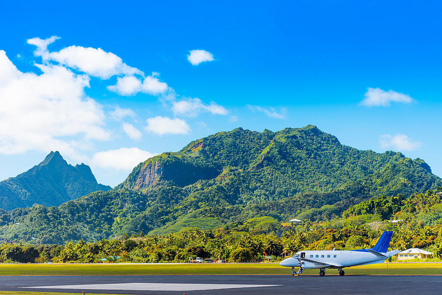 The plane at the airport on a background of mountain scenery, Aitutaki Island, Cook Islands. Copy space for text Photograph by Gerold Grotelueschen