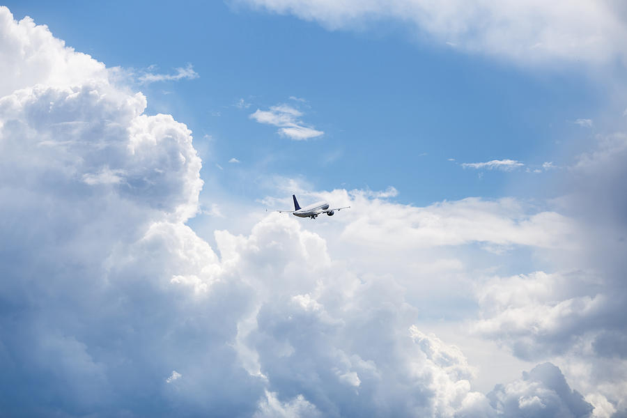 The Plane Flies In The Sky In Beautiful Clouds Photograph by TatyanaTitova