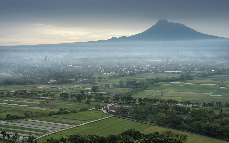 The Prambanan temple with the Merapi volcano in the background Photograph by Anges Van der Logt