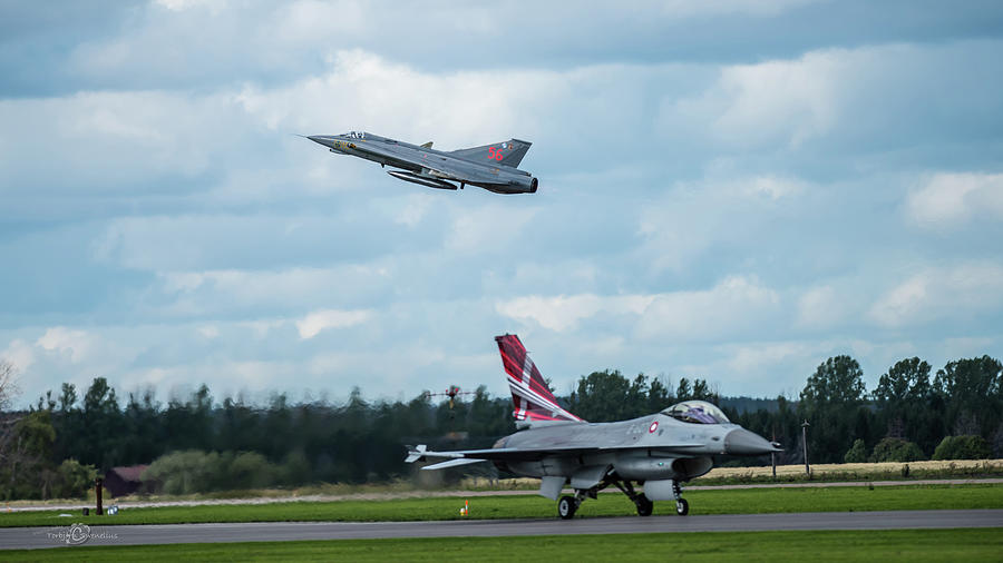The retired Swedish J35 Draken take off and the taxing Danish F16 Fighting Falcon Photograph by Torbjorn Swenelius