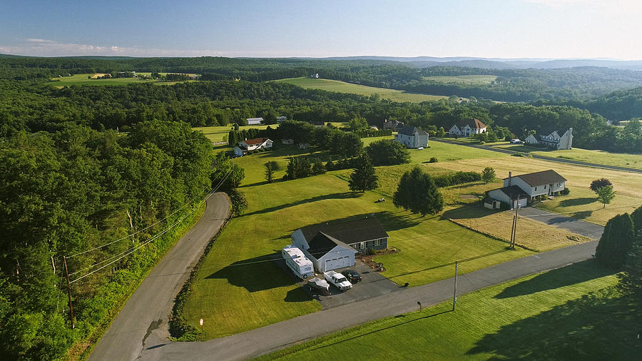 The scenery aerial view of Poconos, Monroe County, Pennsylvania. The sunny summer morning. The panoramic overview over the field and forest to the Kunkletown, then to the small farm near by the road. Photograph by Alex Potemkin