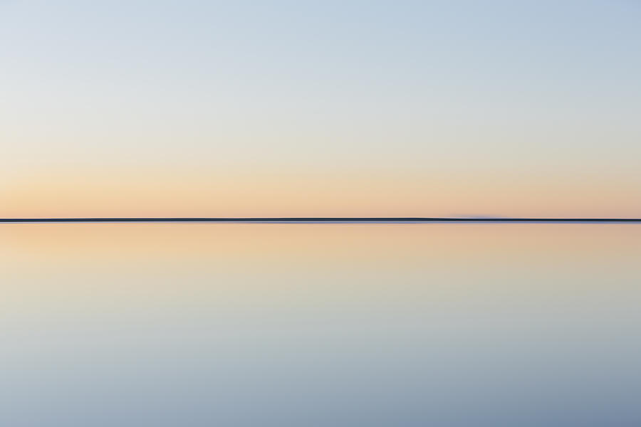 The view to the clear line of the horizon where land meets sky, across the flooded surface of Bonneville Salt Flats. Dawn light, Photograph by Mint Images