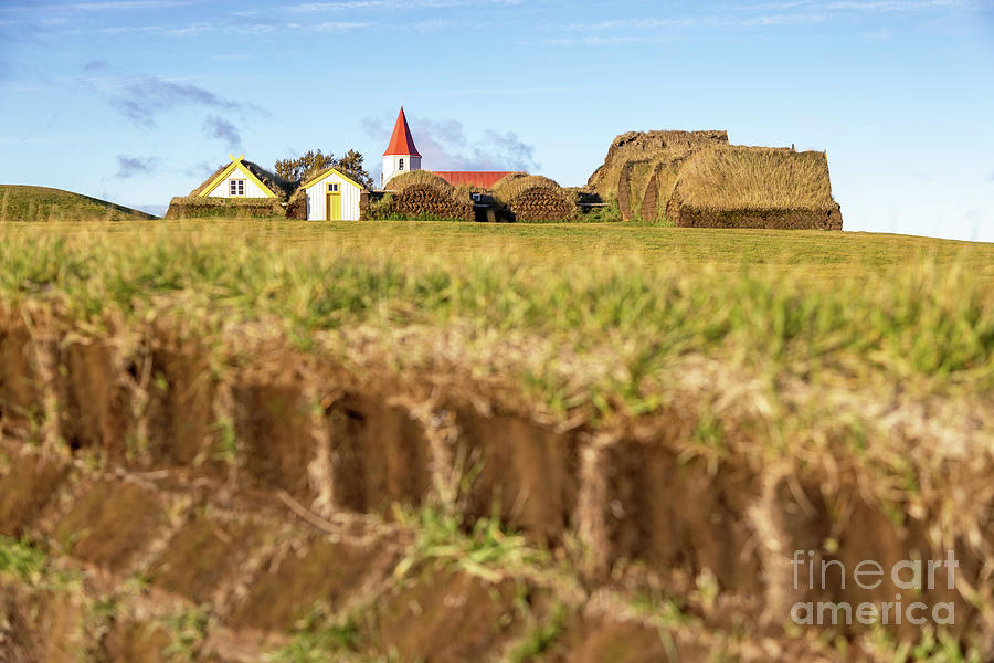 The village of Glaumbaer, Iceland, with traditional turf covered houses and small red and white wooden church. The sod bricks and grass roof insulates against the hard cold winters Photograph by Jane Rix