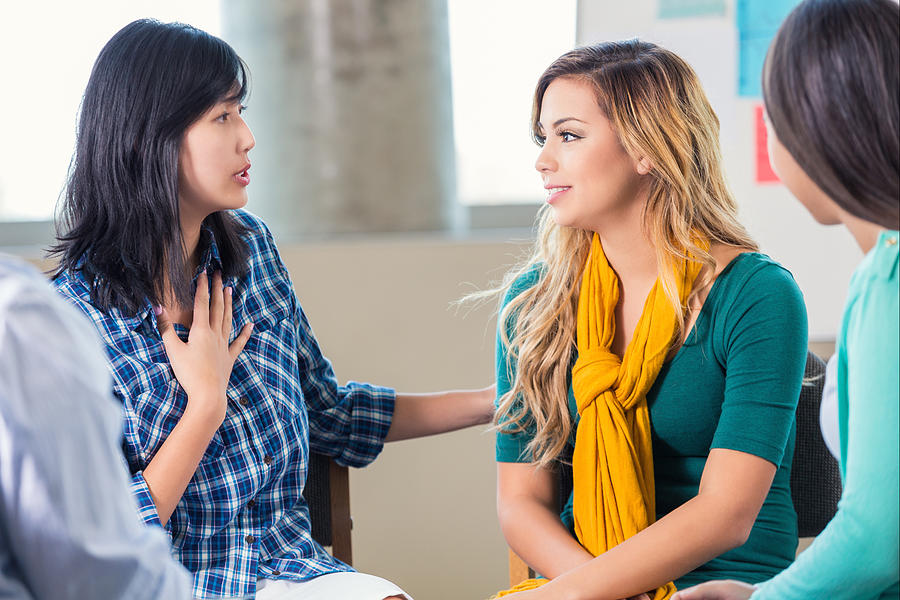 Therapist counsels teenage girl in support group Photograph by SDI Productions