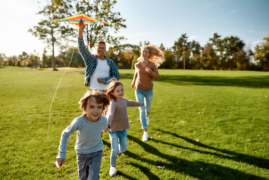 There are no words to describe how special kids are. Happy family playing a kite. Outdoor family weekend Photograph by LanaStock