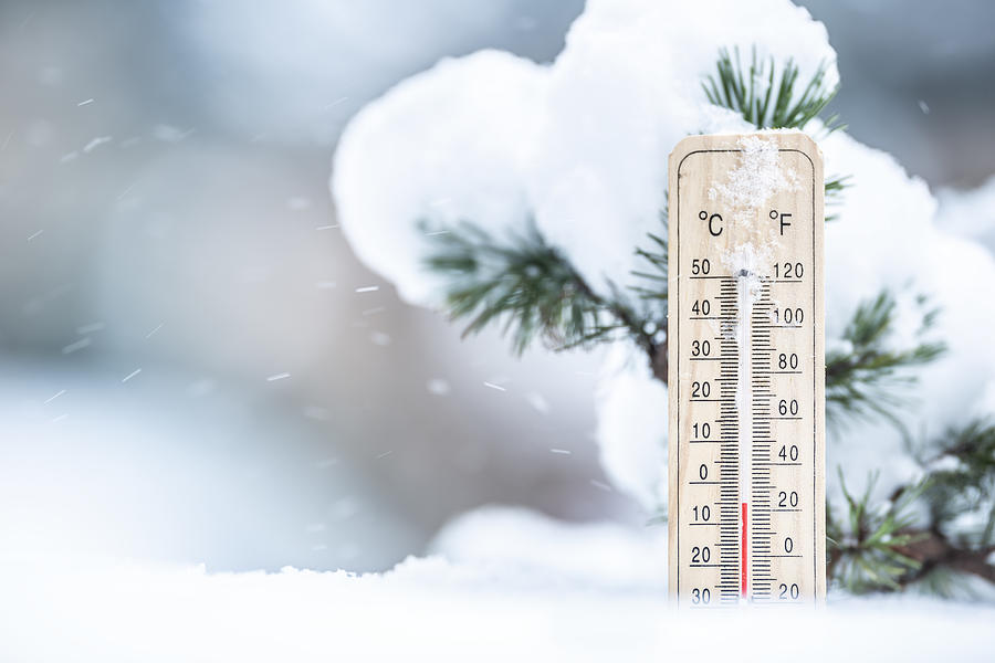 Thermometer in the snow shows low temperatures in Celsius and Farenhaits. Photograph by SimpleImages