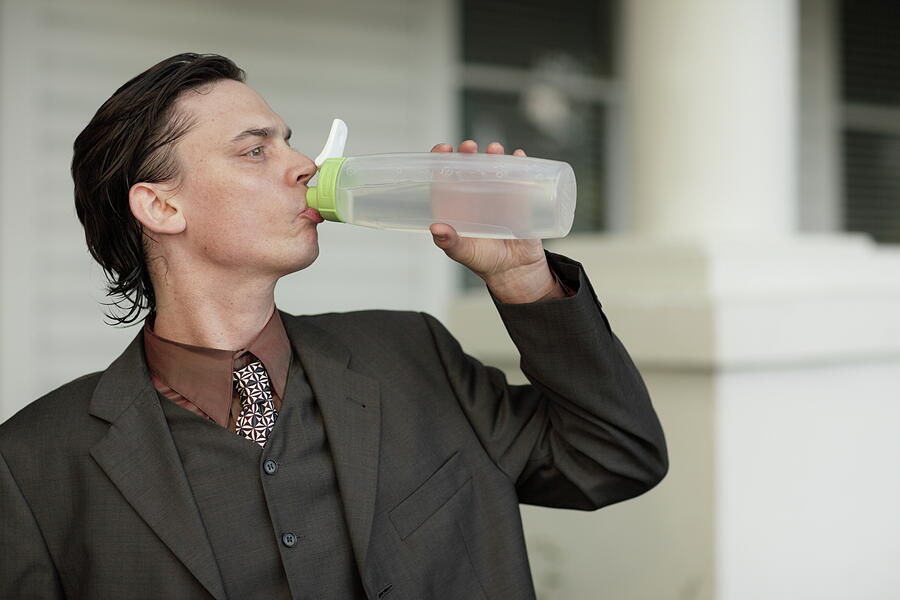 Bottle Photograph - Thirsty businessman drinking from a water bottle by Felix Mizioznikov