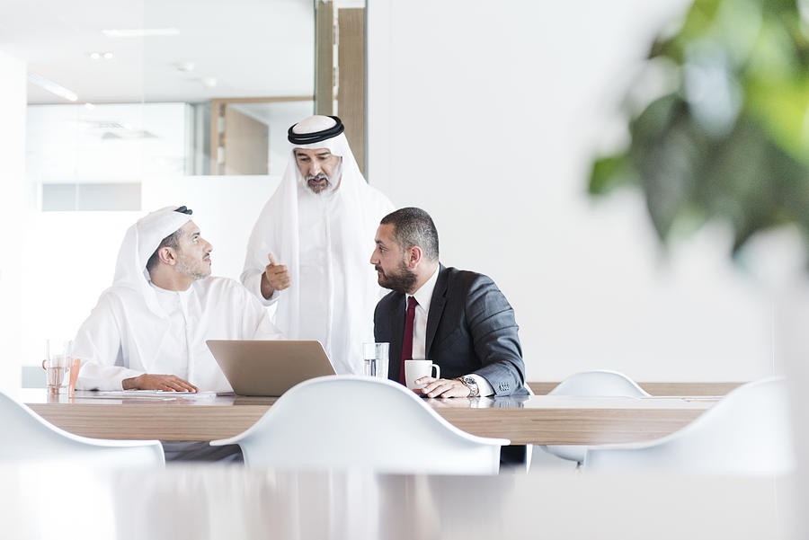 Three Arab businessmen in business meeting in modern office Photograph by JohnnyGreig