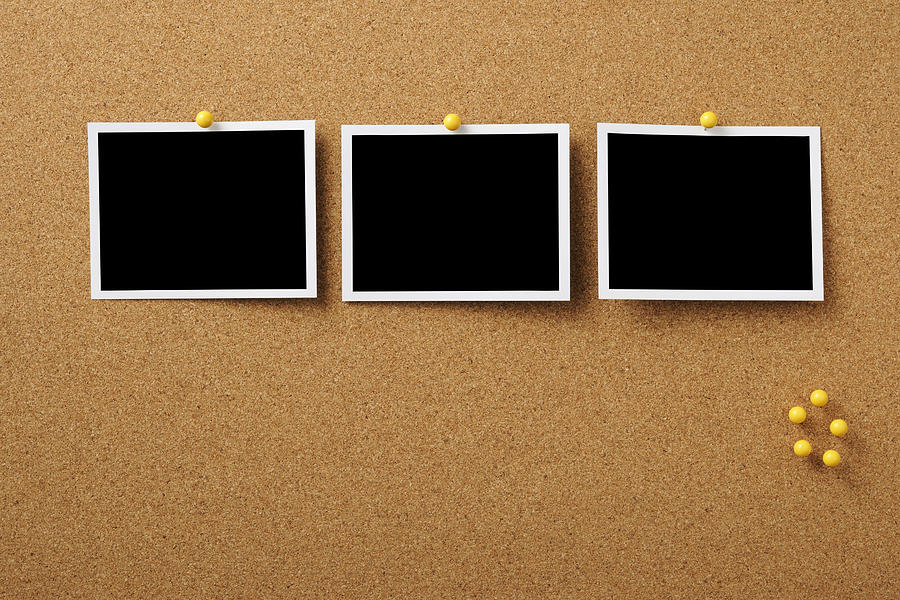 Three blank Polaroid pinned on cork board with yellow thumbtack Photograph by Kyoshino