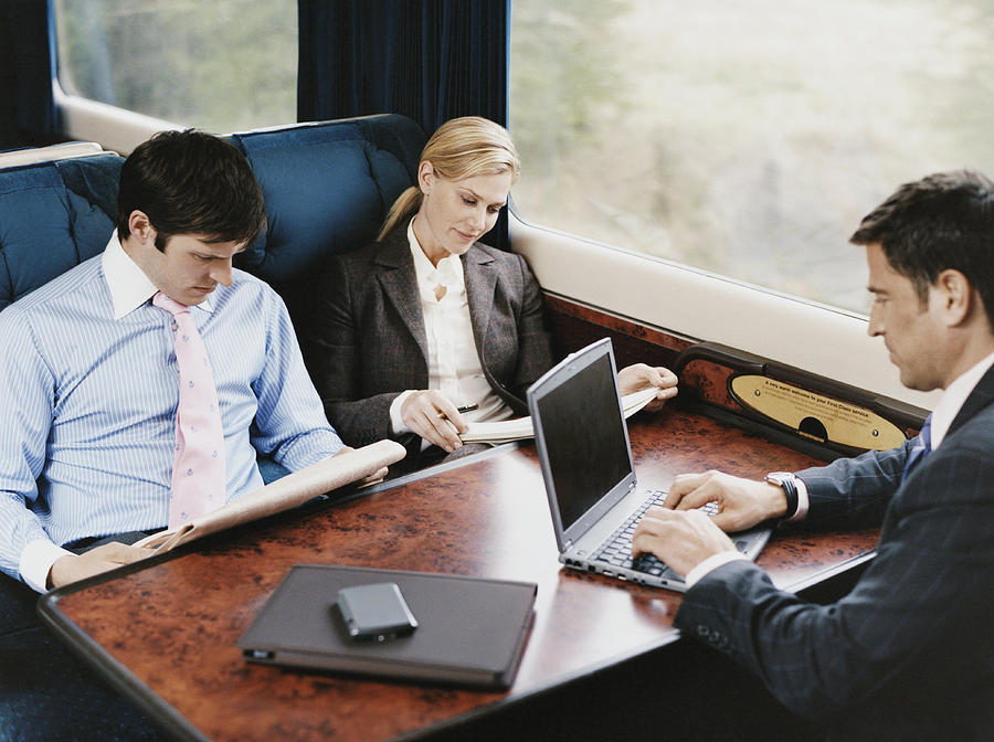 Three Business Executives Sitting on a Passenger Train Photograph by Digital Vision.