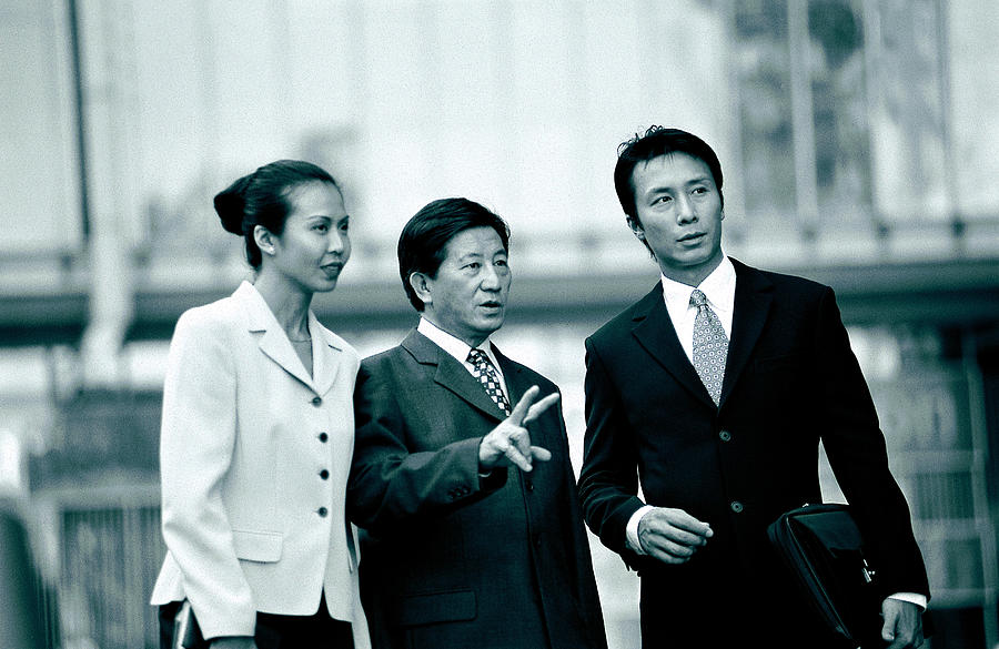 Three businesspeople talking together Photograph by Photodisc