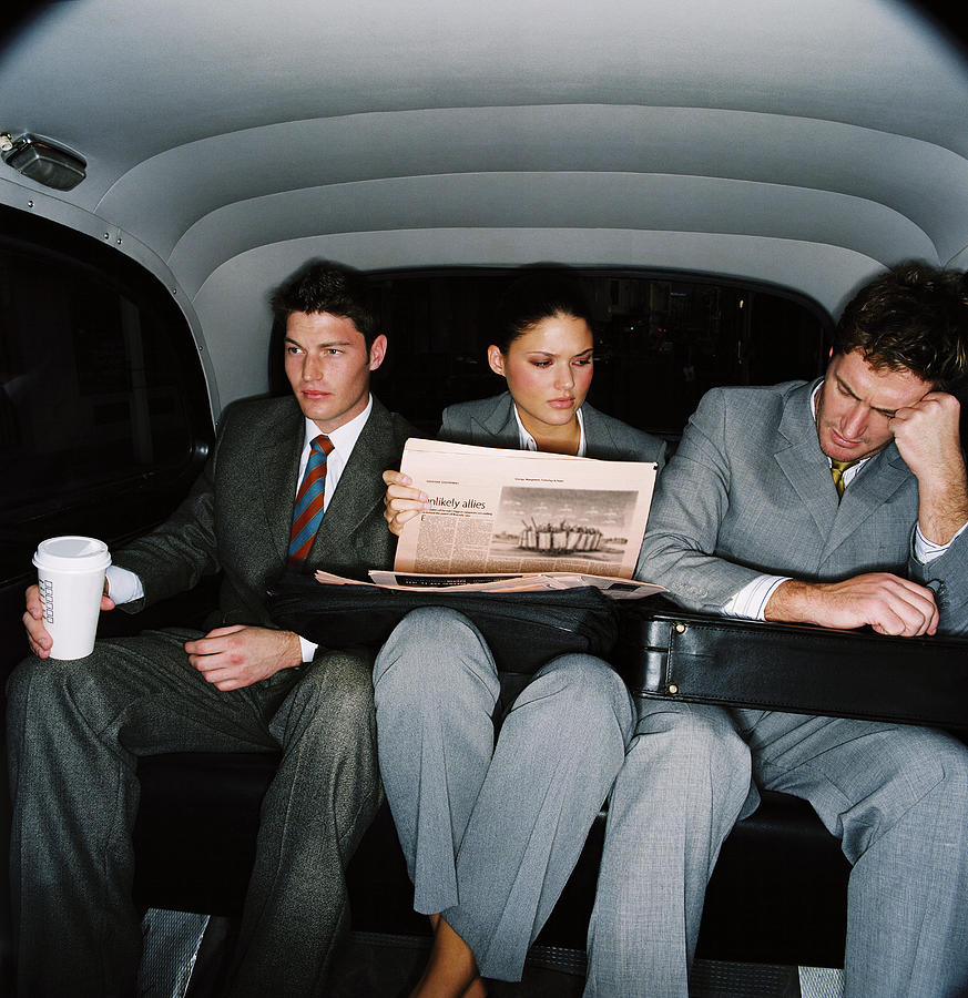 Three Co-workers Sitting In The Backseat Of A Car; Tired Photograph by George Doyle