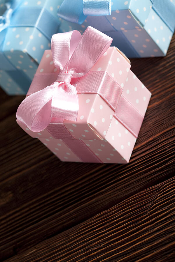 Three colored gift boxes on wooden background Photograph by Tedestudio